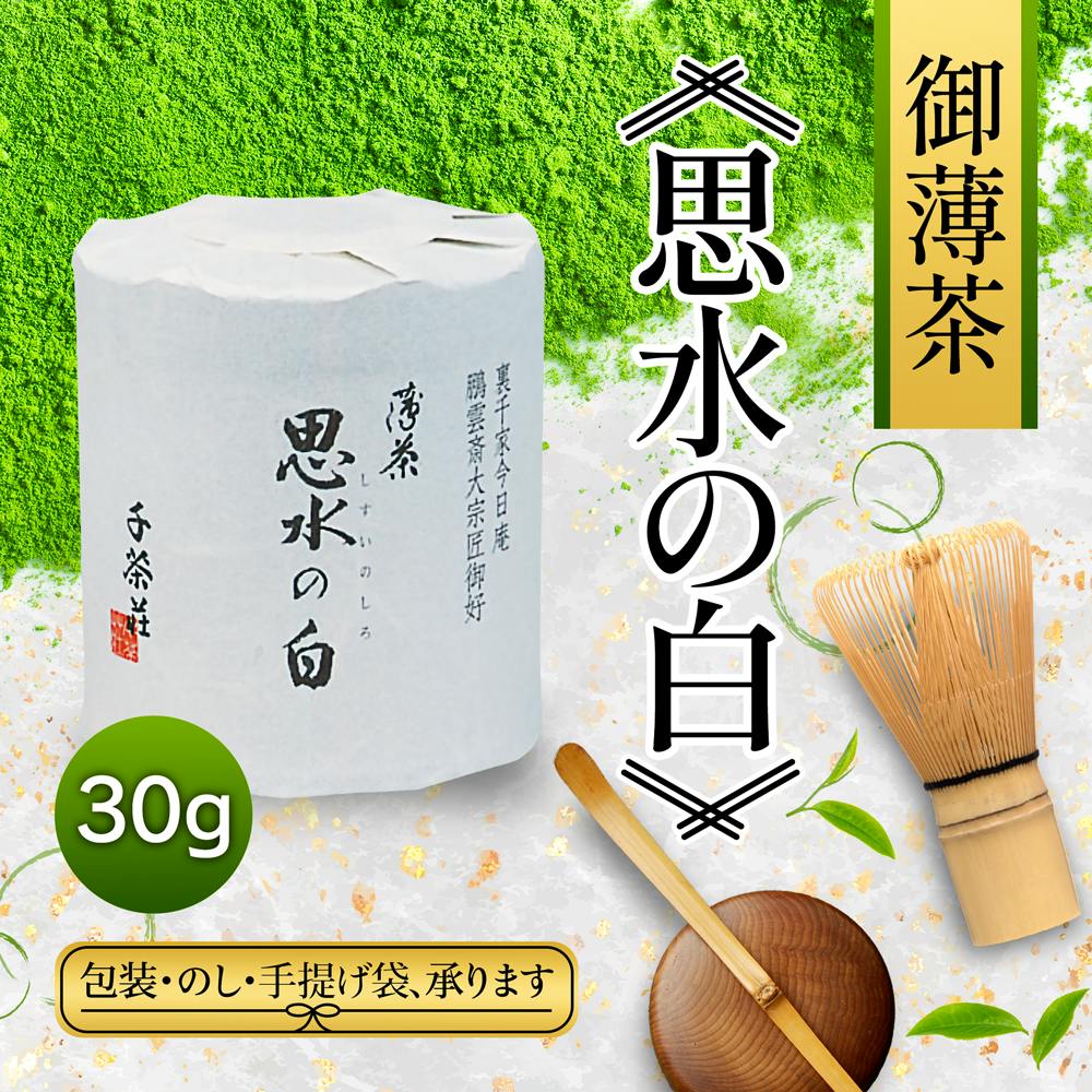 A wrapped 30g package of matcha green tea shown with a bamboo whisk and bamboo scoop on a powdered matcha background.