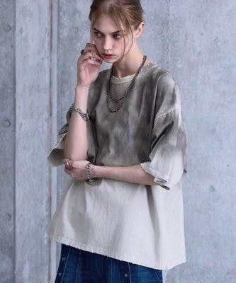 Woman wearing the SERACE vintage design loose gradation women's cotton t-shirt in front of a concrete wall.
