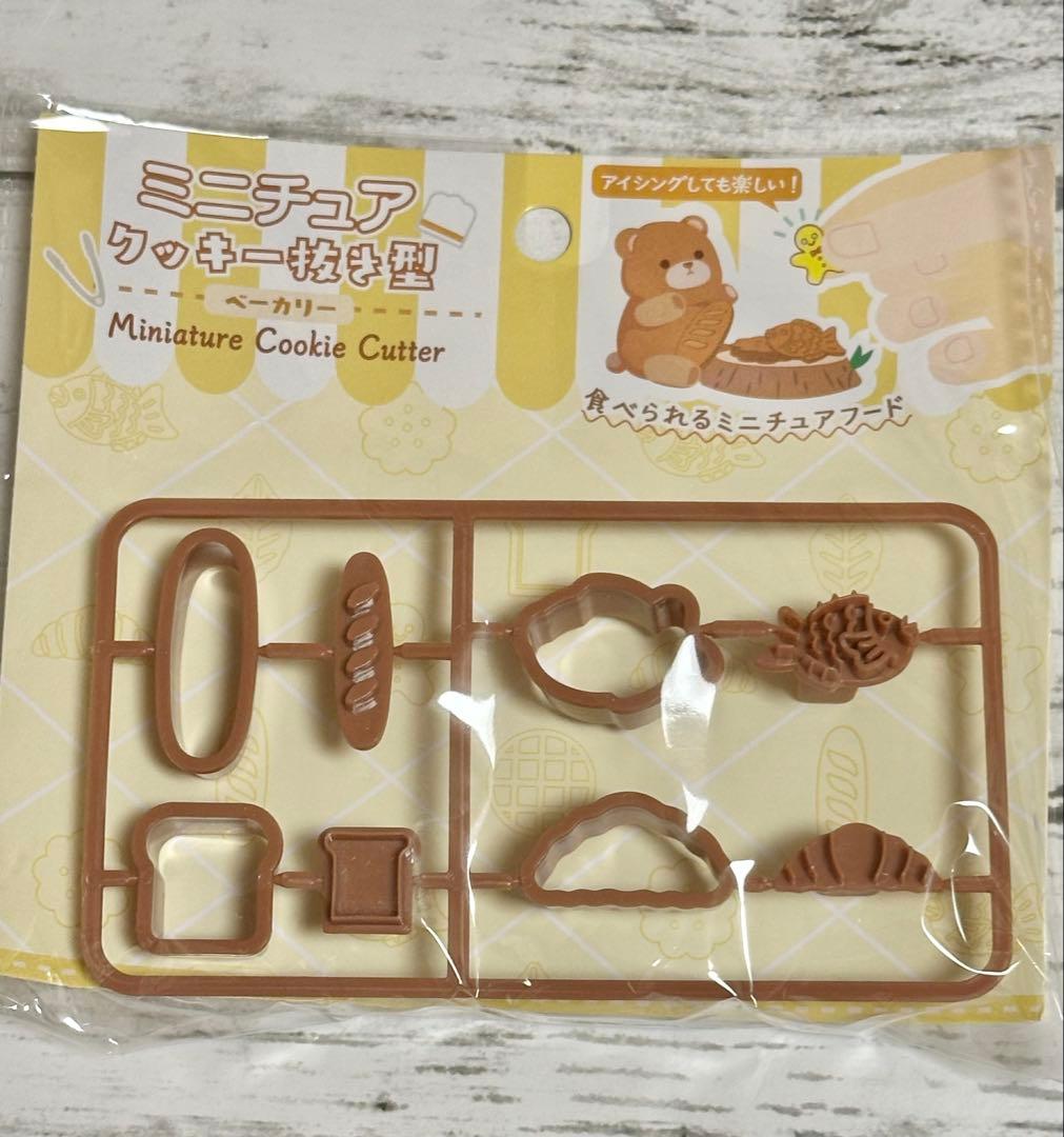 Packaged miniature cookie cutter set showing multiple small cookie-shaped cutters in a plastic frame inside clear packaging with a Japanese label.