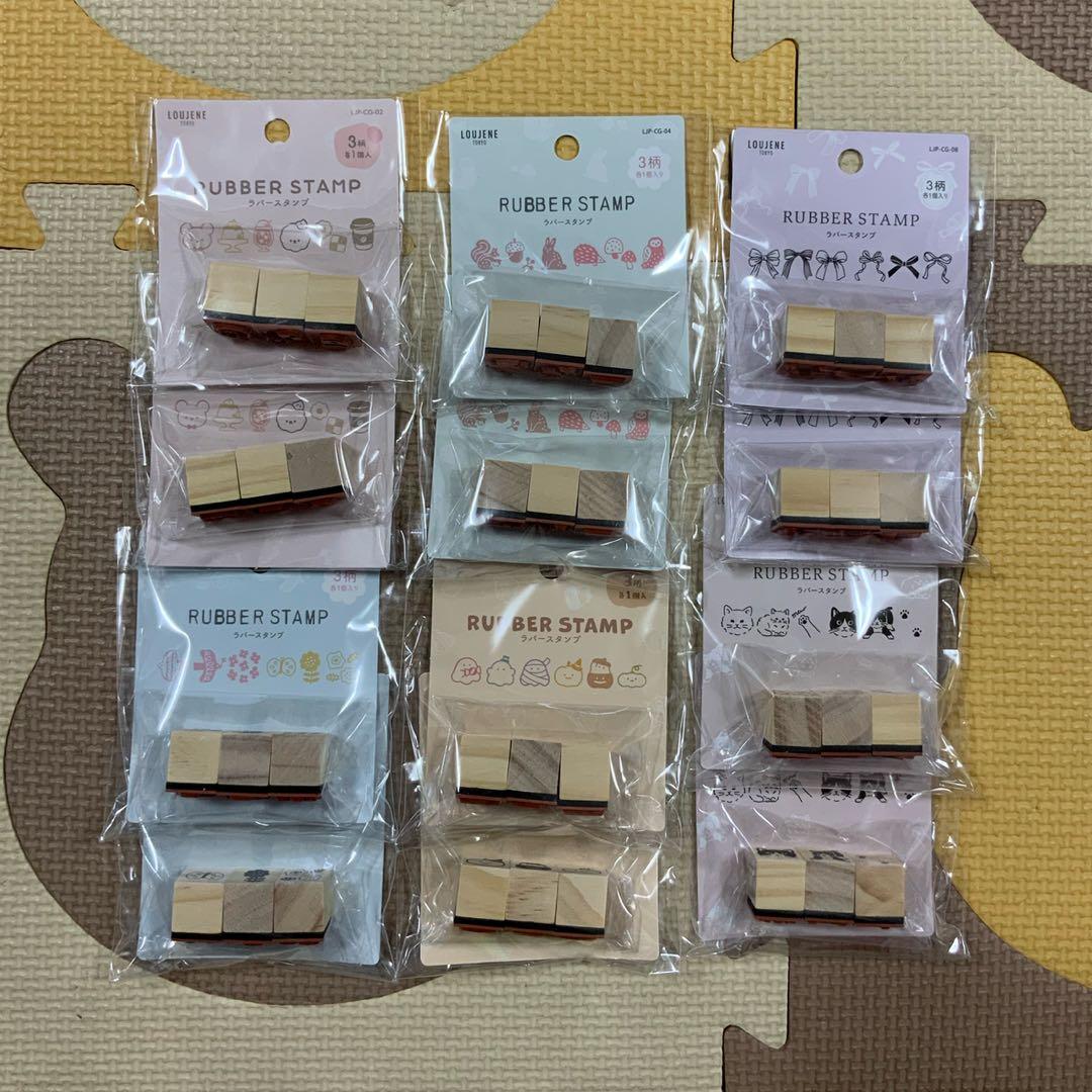 Twelve small Seria rubber stamps in original clear plastic packaging arranged in three columns on a patterned foam mat.