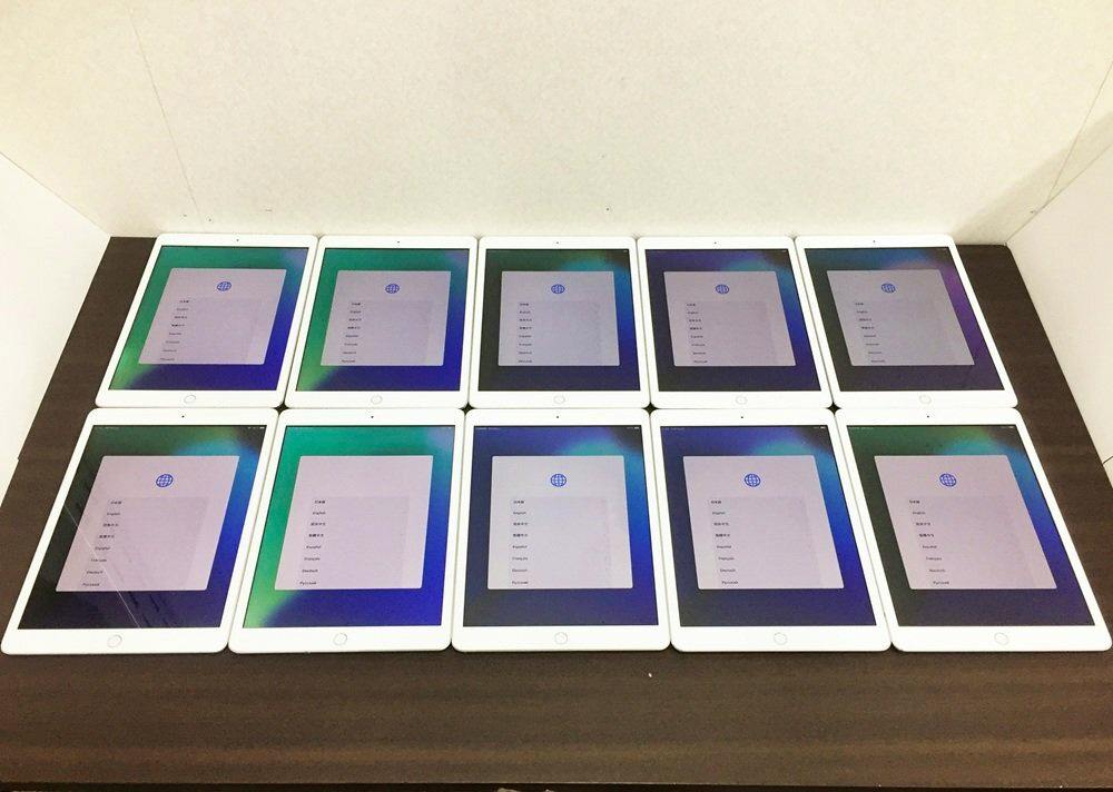 Ten silver Apple iPad tablets (10.2-inch, 7th generation) arranged in two rows showing their setup screens.