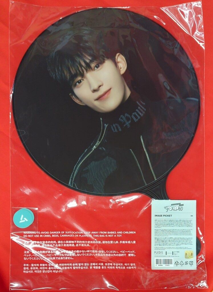 Plastic-wrapped round paper fan (image picket) showing a young man's portrait on a red backing.