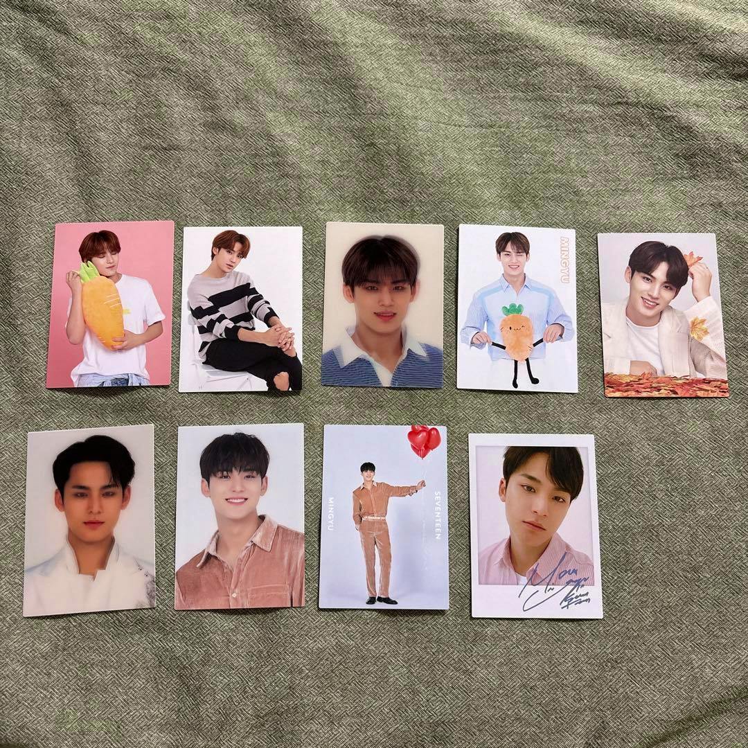 Nine SEVENTEEN Mingyu photocards laid out on a textured cloth background showing various portrait designs.