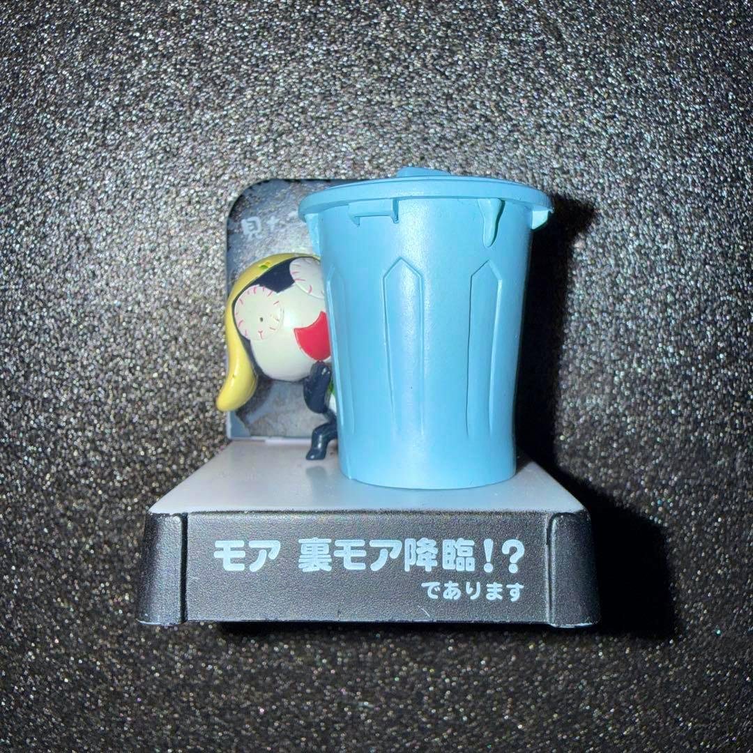 Front view of the ケロロ軍曹 タママ二等兵 plastic figure partially obscured by a blue trash-can prop on a display base with Japanese text.