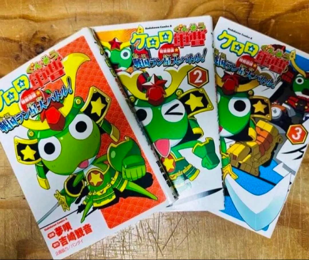 Three comic book volumes from the ケロロ軍曹 set fanned on a wooden surface showing their front covers.