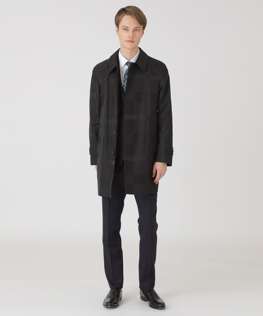 Male model wearing the men's shadow-check laminated stand-collar coat shown full-length against a white background.