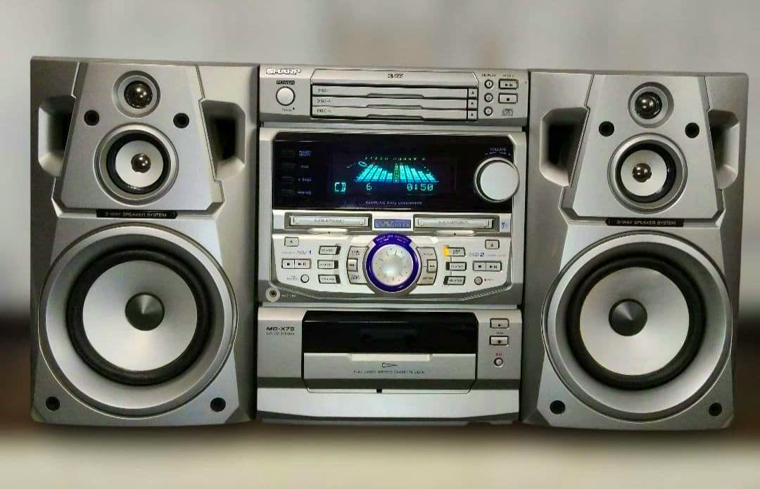 Front view photo of the SHARP MD-X75 stereo system with main unit and two speakers.