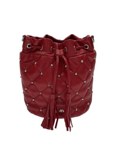 Red quilted drawstring shoulder bucket bag with tassel cords and metal stud detailing.