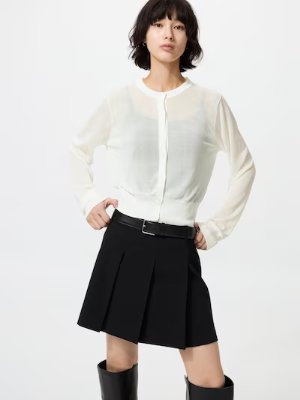 Model wearing a sheer white crew-neck short cardigan buttoned at the front.