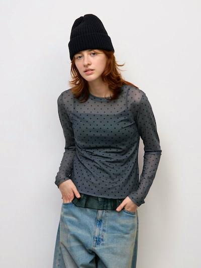 Model wearing the women's long-sleeve sheer polka-dot polyester T shown from the front.