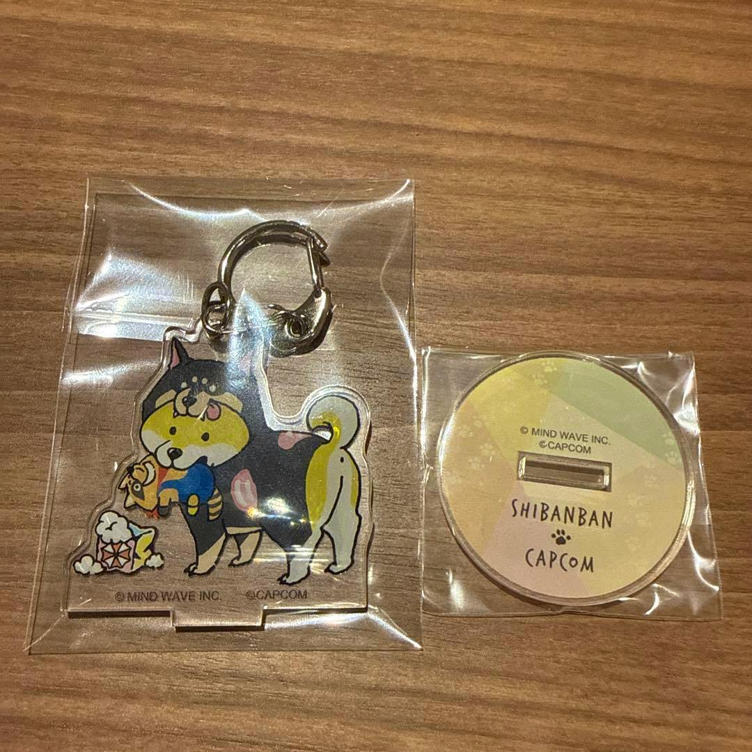 Packaged SHIBANBAN CAPCOM acrylic stand keyholder and round acrylic base displayed on a wooden surface.