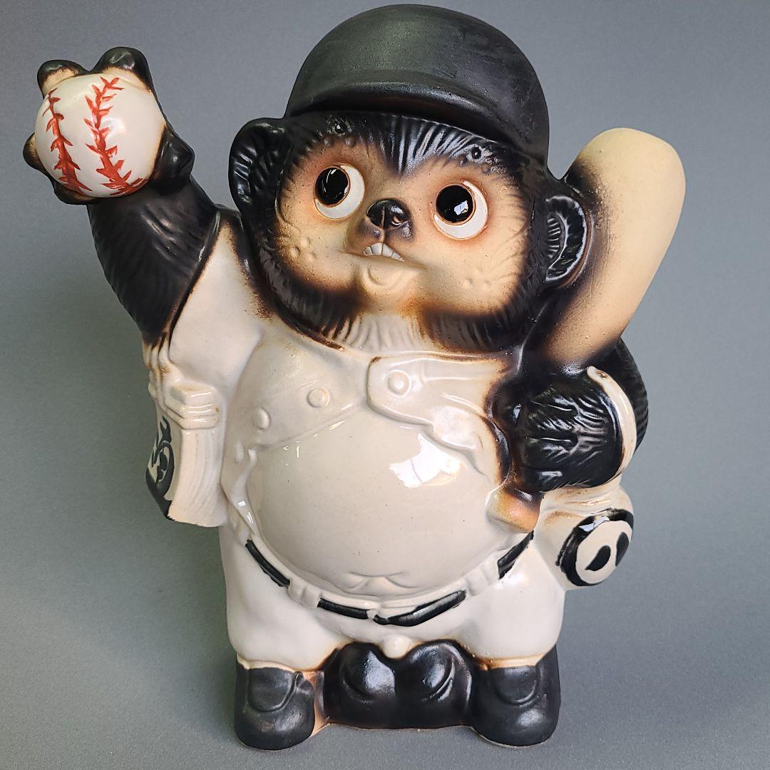 Front view of a Shigaraki-yaki ceramic tanuki figure wearing a baseball uniform and holding a baseball.