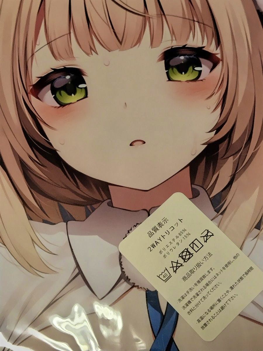 Close-up photo of the illustrated character's face printed on the pillow cover with a care label sticker visible.