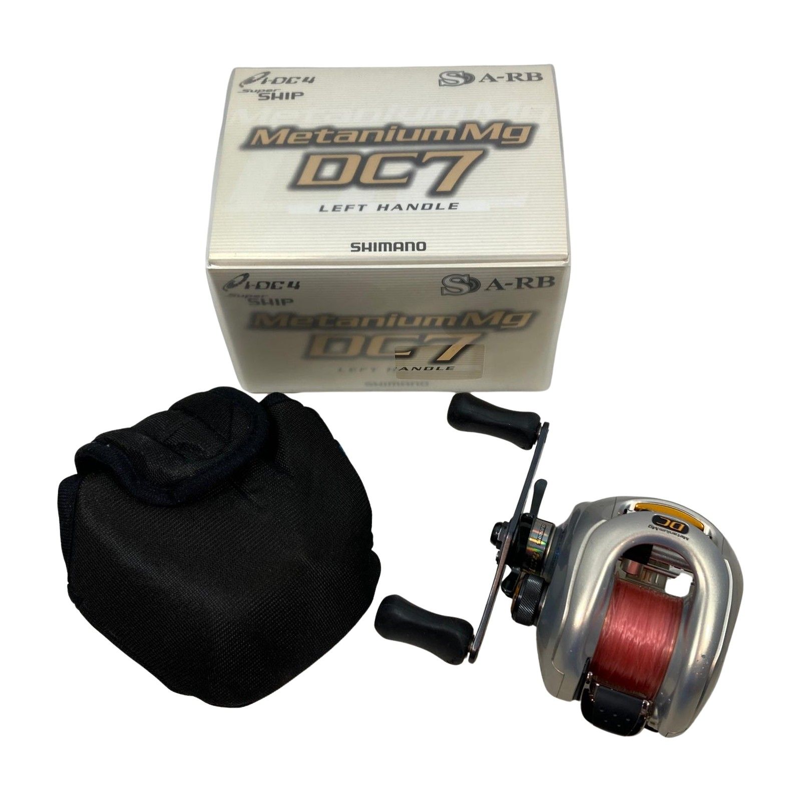 Shimano Metanium Mg DC7 left-handle baitcasting fishing reel shown with its box and a black protective pouch.