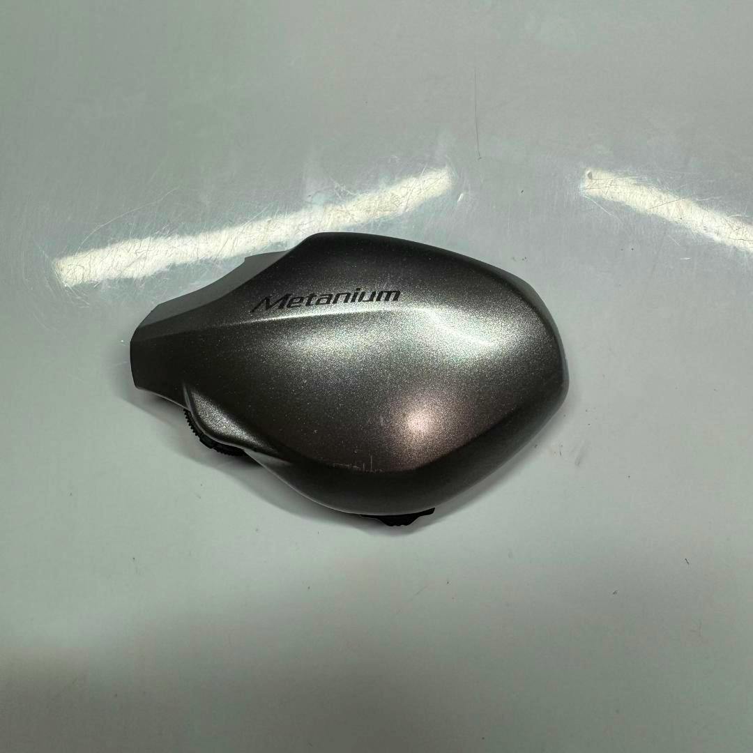 Right-side body plate for a 13 Metanium HG Shimano fishing reel with the "Metanium" logo visible on a white background.