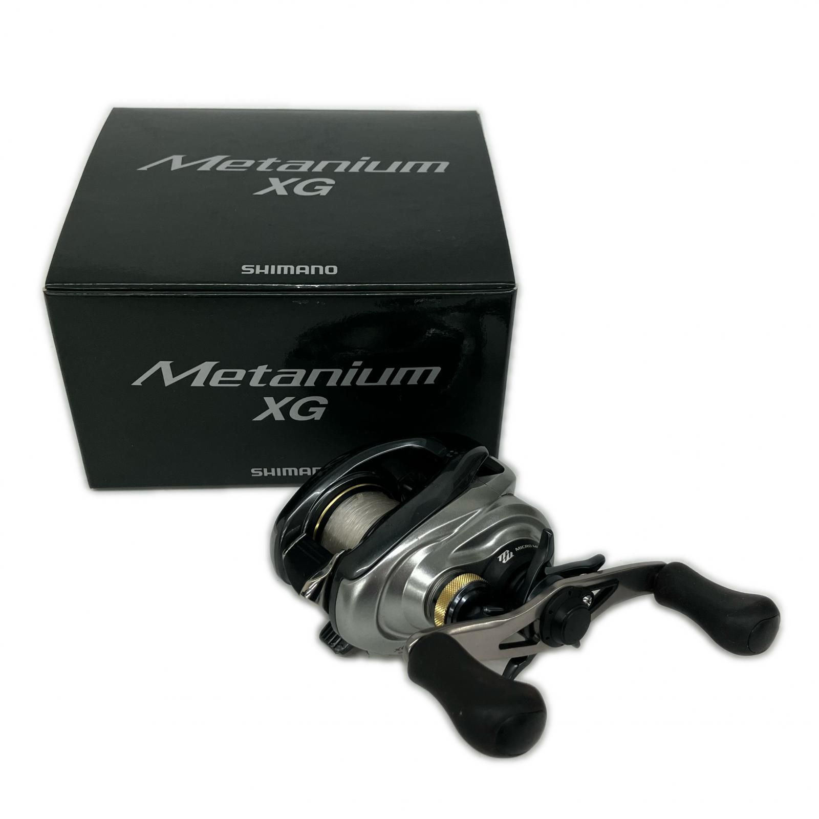 A Shimano Metanium XG baitcasting reel shown alongside its Metanium XG branded box.