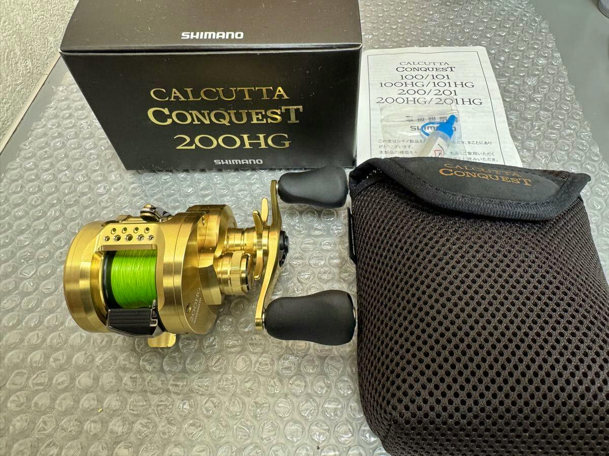 Gold SHIMANO Calcutta Conquest 200HG baitcasting fishing reel with green line shown next to its box, instruction manual, and a protective pouch.