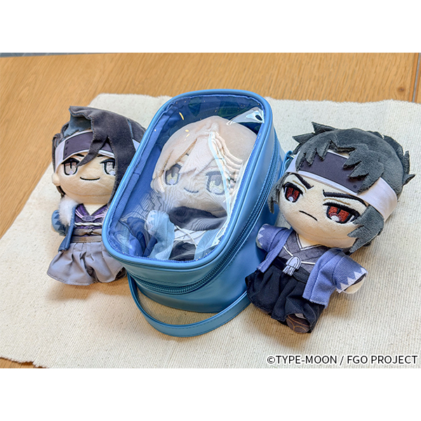 Blue polyester pouch with a clear top window displayed on a surface alongside three small plush toys, one placed inside the pouch.