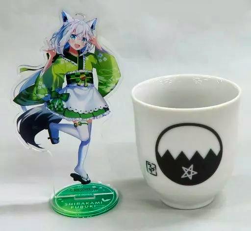 Acrylic decorative stand of Shirakami Fubuki displayed next to a small white cup.