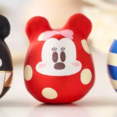 Front view of a red Minnie だるま (NEW YEAR 2025) with white polka dots and a Minnie face.