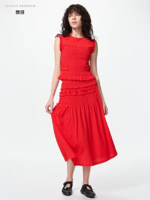 A model wearing a red shirred skirt and matching shirred top against a white background.