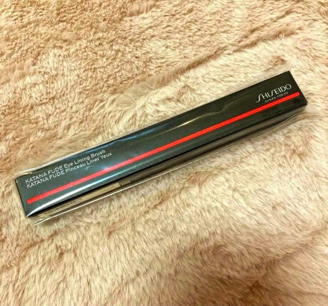 Packaged SHISEIDO KATANA FUDE eye lining brush box shown on a beige plush surface.