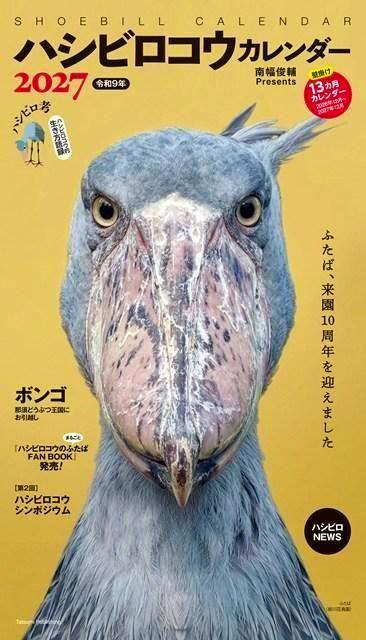 Cover of the ハシビロコウカレンダー2027 showing a close-up photo of a shoebill bird on a yellow background with Japanese title text.