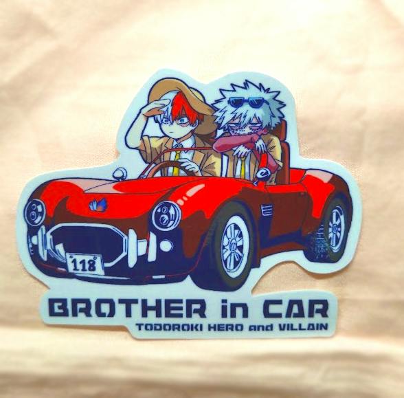 Photograph of the paper sticker depicting two characters in a red convertible car with the text "BROTHER in CAR".