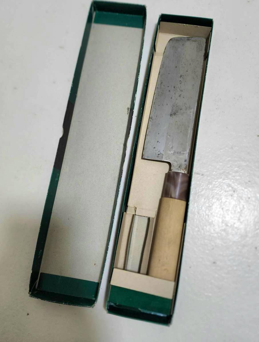 A chef knife with a metal blade and wooden handle shown inside an open green box.