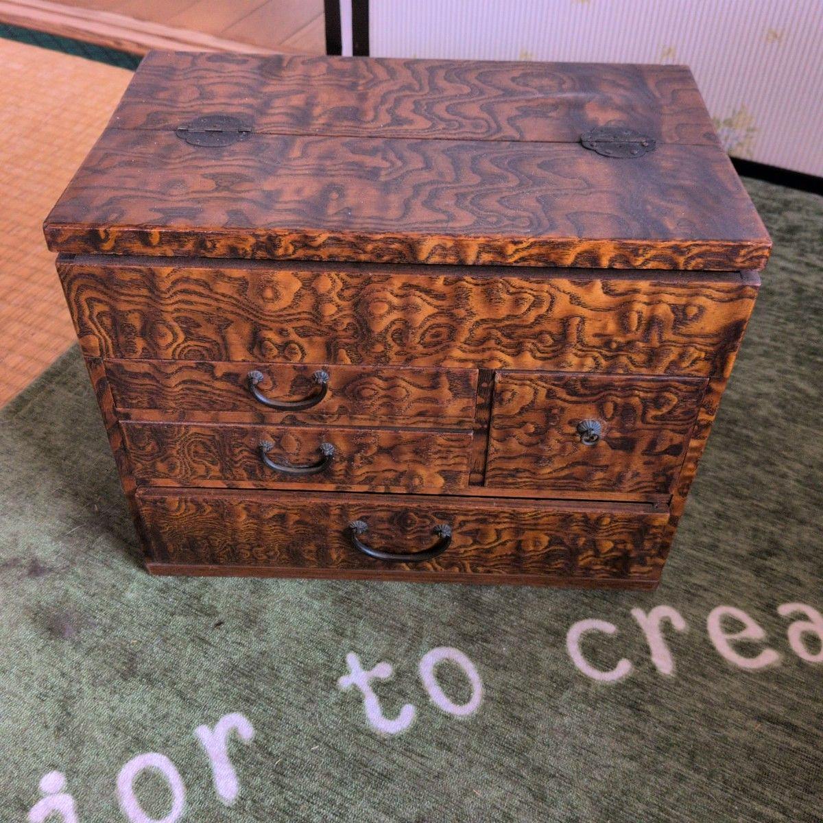 A retro Japanese-style wooden mini chest with visible wood grain, three drawers, and metal handles shown closed on a carpet.