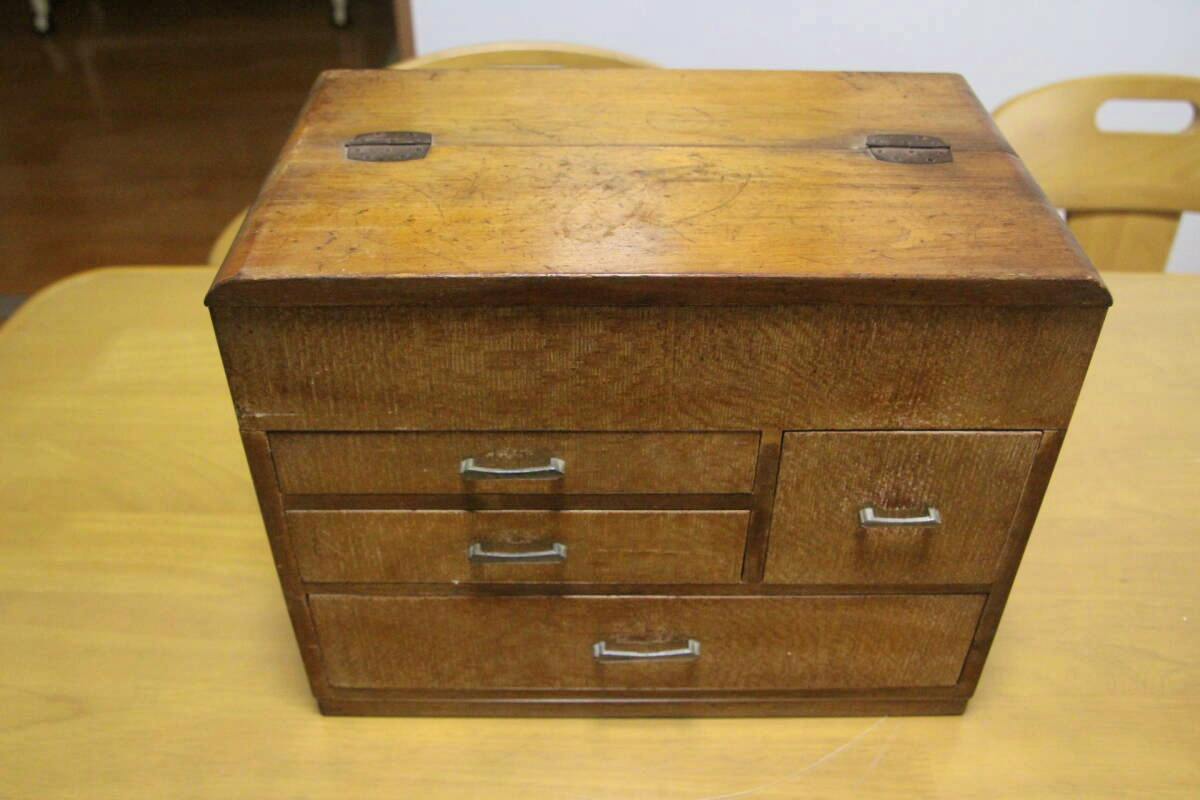 Wooden Showa-era retro sewing box (drawer chest) with multiple drawers sitting on a table.