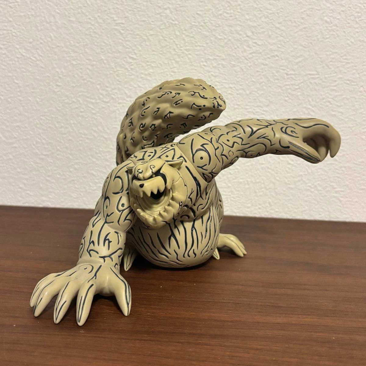Photograph of the Shukaku (守鶴) soft vinyl figure from Naruto placed on a wood surface, shown from a front-left angle with mouth open.