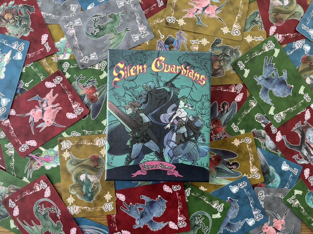Silent Guardians board game box centered on a spread of scattered colorful game cards.