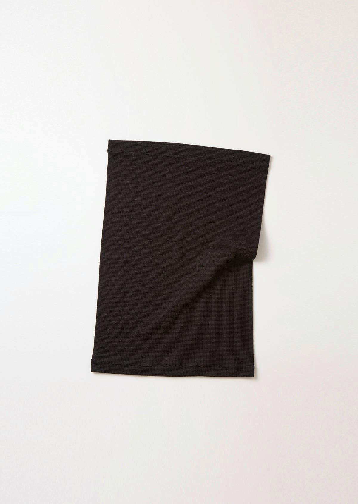 A black belly warmer laid flat on a white background.