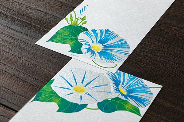 Close-up photo of letter paper showing blue and white morning-glory flowers printed on textured paper.