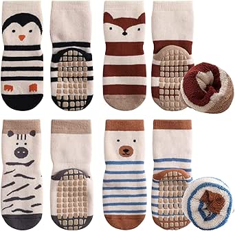 Eight cotton baby socks (four pairs) with animal patterns and anti-slip rubber grips arranged in two rows, with two socks rolled to show the soles.