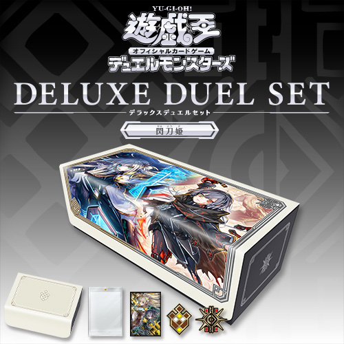 Photo of a Yu-Gi-Oh! Deluxe Duel Set box showing '閃刀姫' artwork and small images of a deck box, card sleeves, and tokens.
