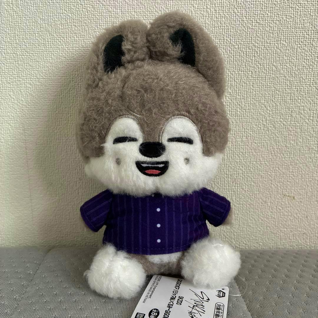 Front view of the SKZOO WolfChan plush wearing a purple striped pajama shirt against a neutral wall background.