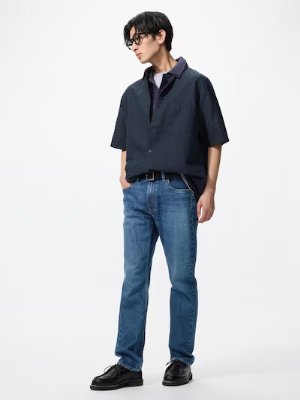 Male model standing against a white background wearing the slim straight jeans.