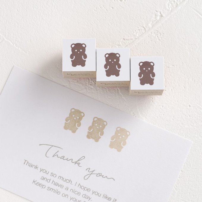 Three small wooden rubber stamps with a bear design shown next to a card stamped with three bears.