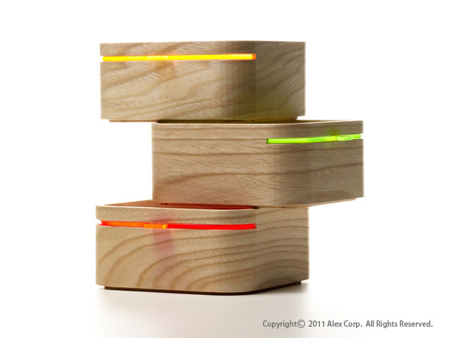 Three small wooden storage boxes stacked, each with a different colored accent strip.