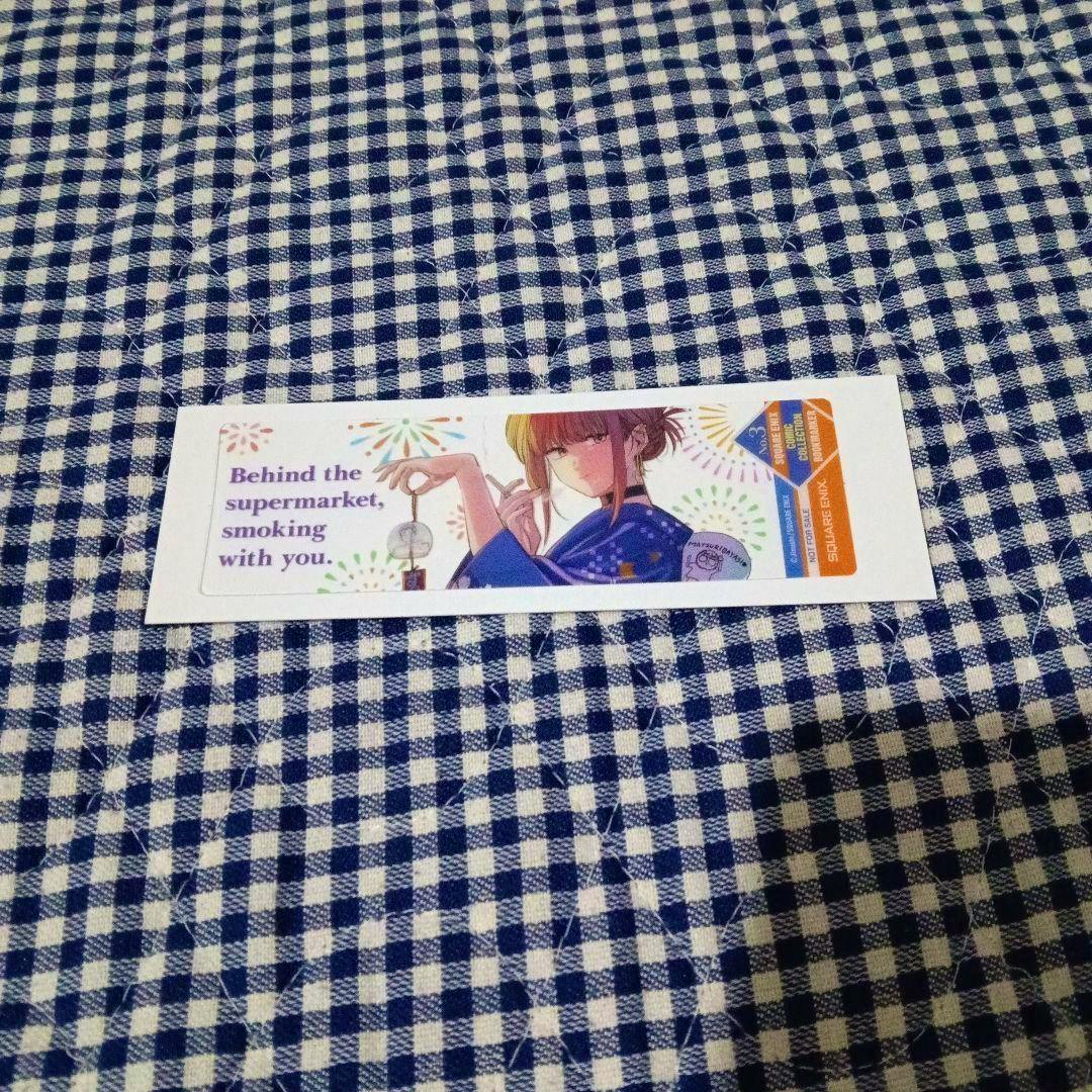 A rectangular art print on blue-and-white checkered fabric showing an illustrated person and the text "Behind the supermarket, smoking with you."