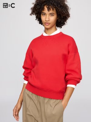 A model wearing a red smooth cotton crew-neck sweater with long sleeves.