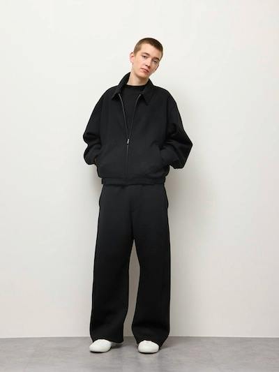 Male model wearing the men's smooth sweat 3D barrel pants in black, shown full-length against a plain background.