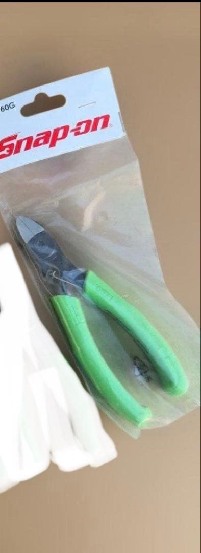 Green-handled Snap-on EPC160G pliers shown in clear plastic retail packaging with a Snap-on header.