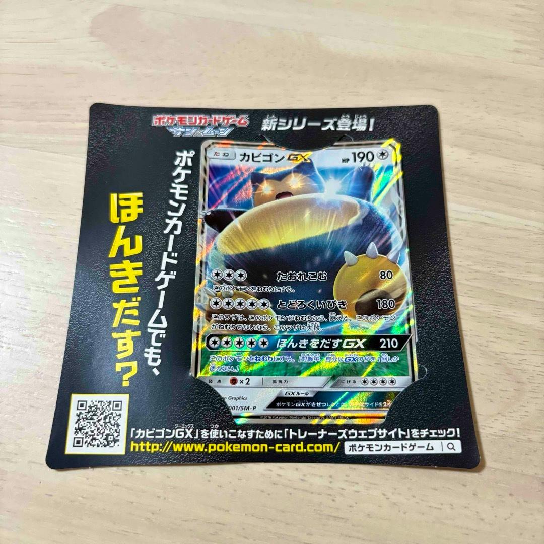 A カビゴンGX (Snorlax GX) trading card displayed in a promotional cardboard mount with Japanese text and a QR code.