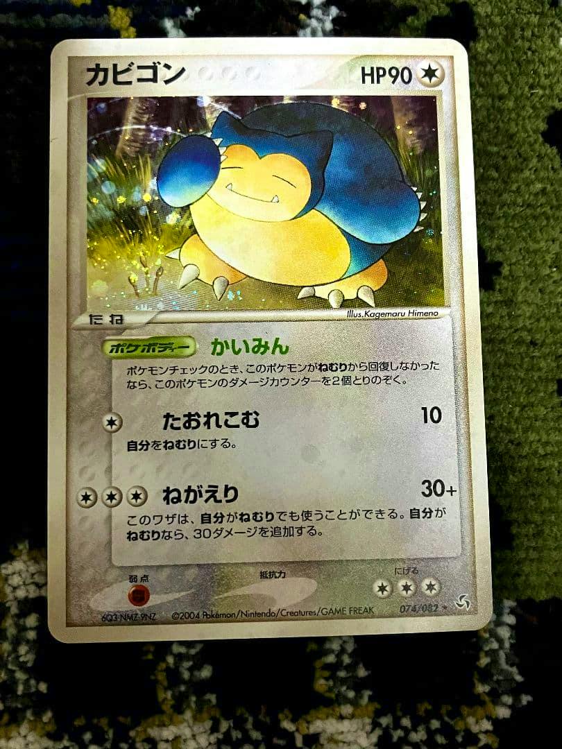 Front of the Japanese Snorlax (カビゴン) trading card showing the holographic artwork, HP, and Japanese text.