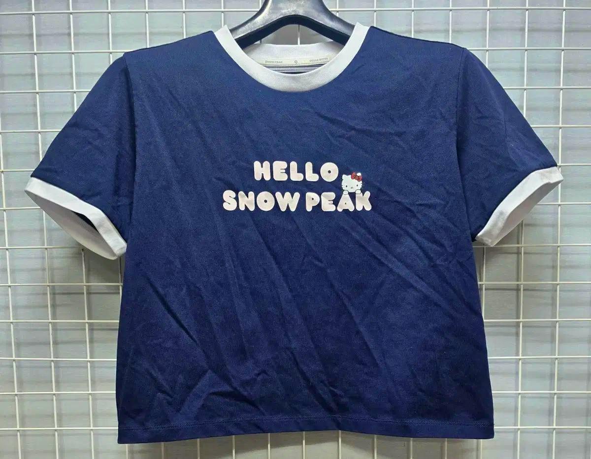 Navy women's short-sleeve T-shirt on a hanger with white ringer collar and cuffs and “HELLO SNOW PEAK” printed on the front.