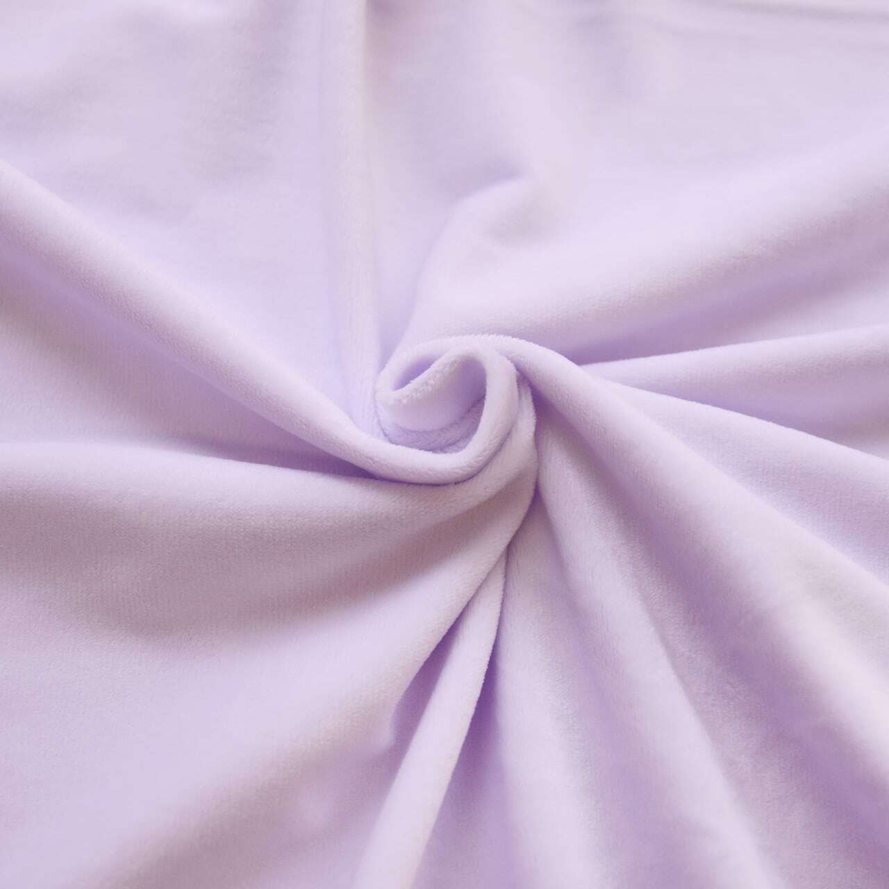 Photo of the pale purple soft pile fabric arranged in a spiral to show its texture.