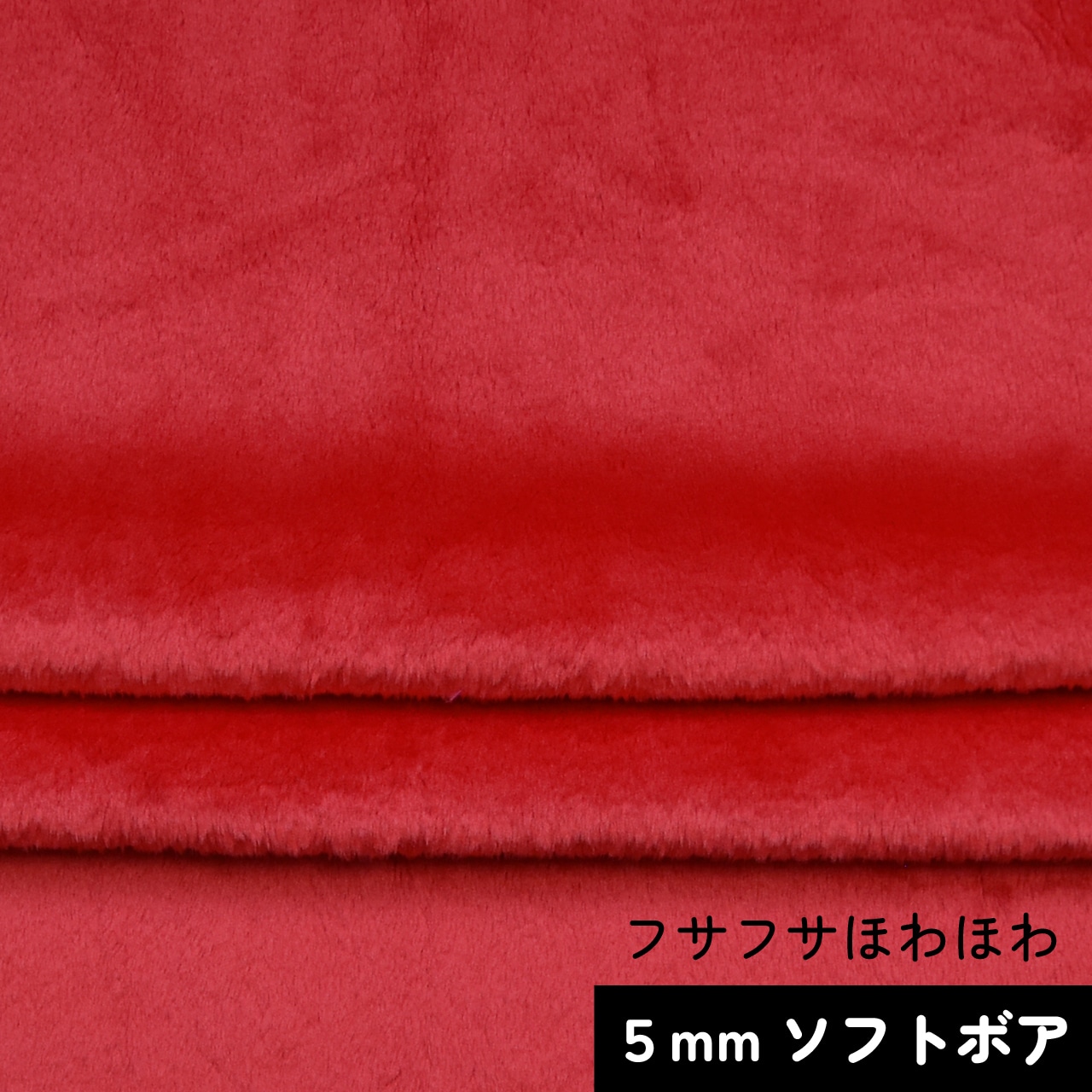 Folded red soft-pile polyester fabric showing its pile texture.